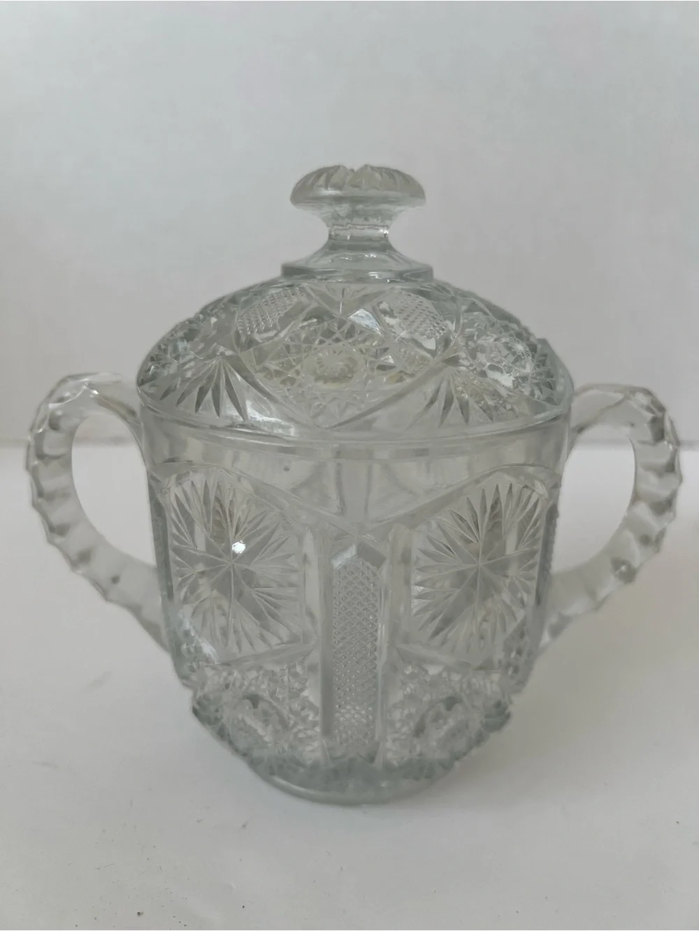 This is a vintage clear pressed-glass covered sugar bowl with 2 handles & lid